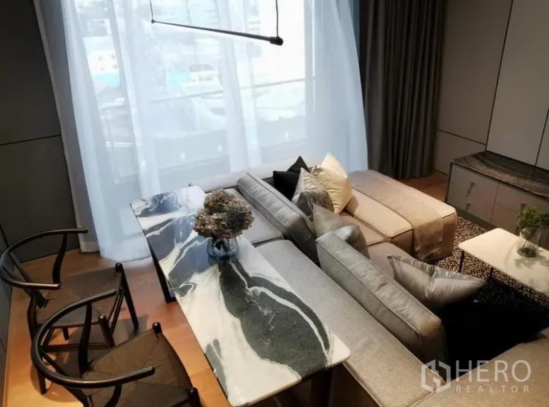 Condominium for rent in Khlong Toei, Bangkok - Top view of marble dining table and sofa set beside tall window