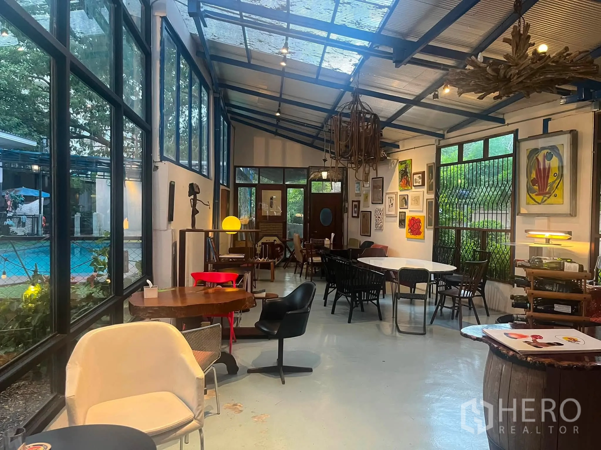 Retail Space for rent in Watthana, Bangkok - Long interior with skylight-style roof, large windows, mixed tables, and artwork displays.