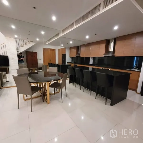 公寓 出租在Khlong Toei, Bangkok - 宽敞厨房，长吧台与吧椅，旁接餐桌。