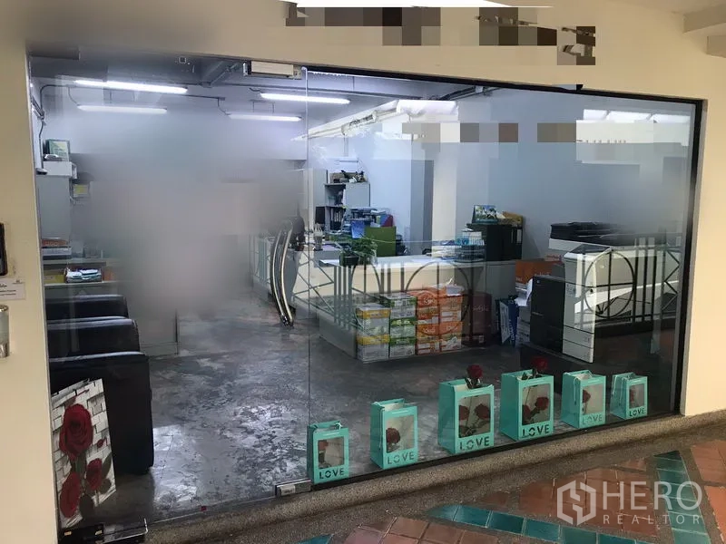 办公空间 出租在Watthana, Bangkok - 玻璃门面办公室入口，开间式工作区，顶灯明亮与抛光水泥地面。
