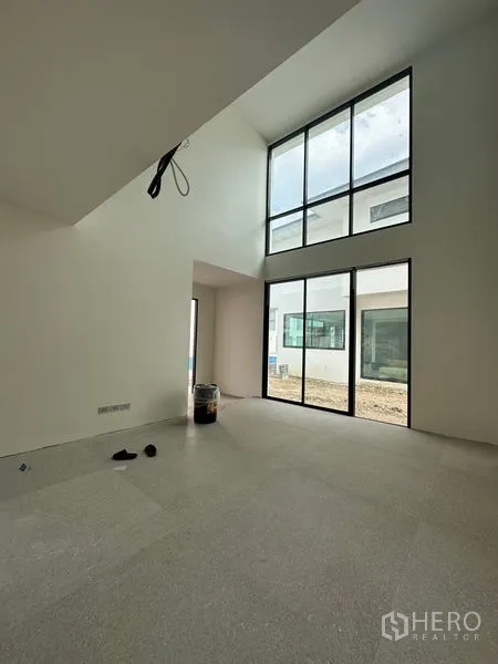 Detached House for rent in Watthana, Bangkok - Double-height living room featuring towering windows that maximize daylight and garden views.