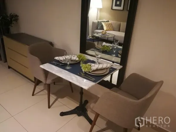 公寓 出租或出售在Watthana, Bangkok - 两人用餐角：大理石小餐桌、软包餐椅与整面镜子，空间明亮。