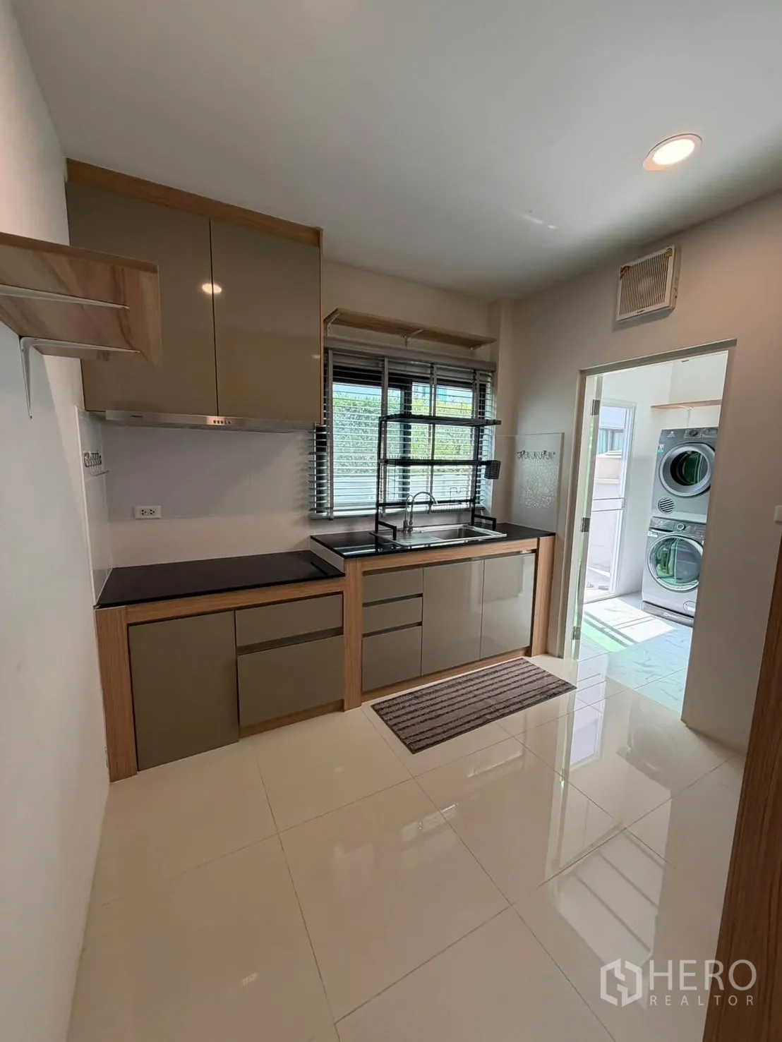 独栋房屋 for rent in Bang Phli, Samut Prakan - 厨房配柜体与水槽，通向洗衣房的门。