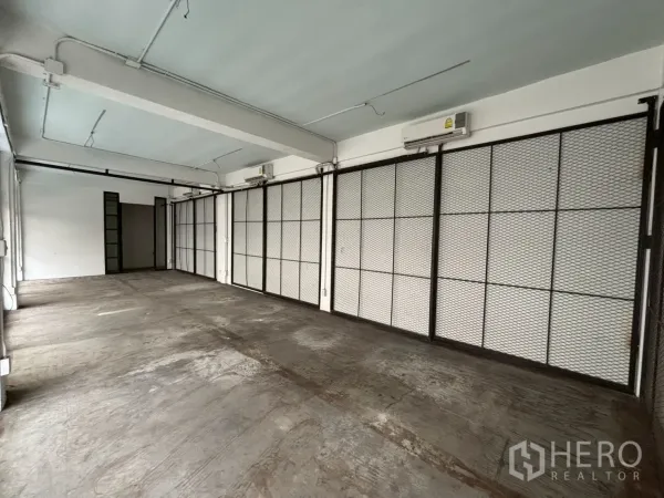 Retail Space for rent - Loft-style retail interior showing split-type air conditioners and sliding mesh panels along one wall.