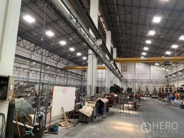Factory for rent in Samut Prakan - Large manufacturing hall with bright LED lighting and dual overhead cranes along the span.