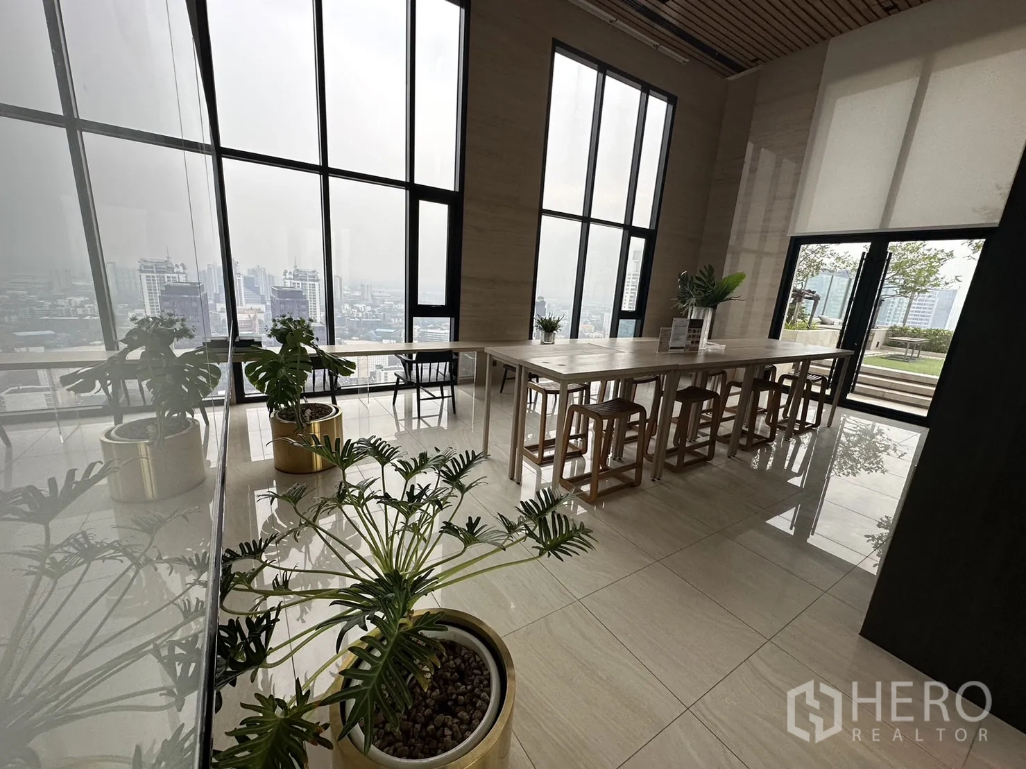 公寓 出租在Watthana, Bangkok - 协作办公区，长桌、绿植与落地窗