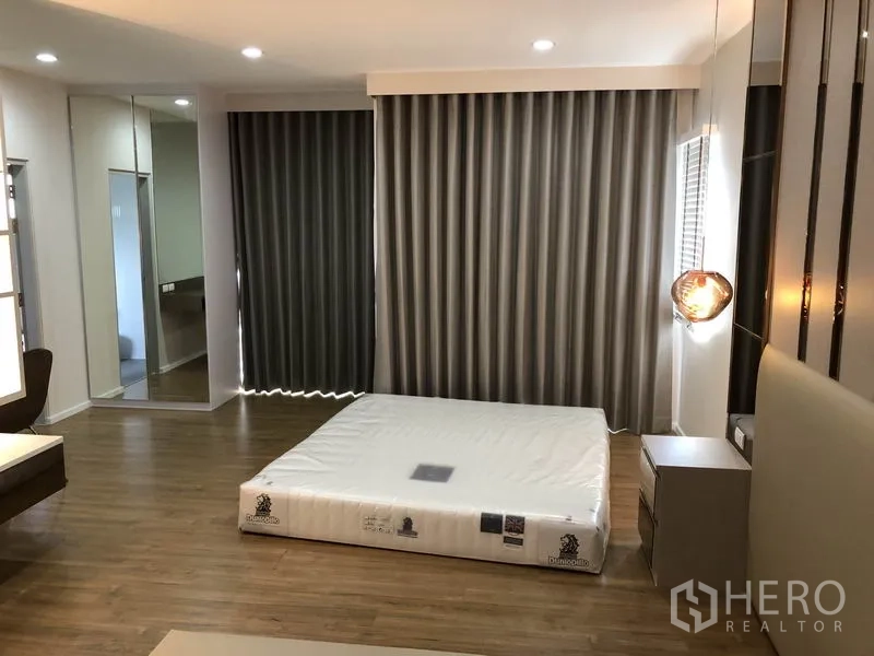 Detached House for rent in Prawet, Bangkok - Large master bedroom with mattress, blackout curtains and wood flooring.