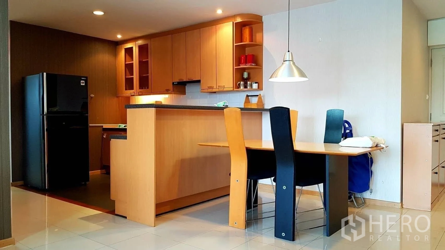 公寓 for rent in Khlong Toei, Bangkok - 开放式厨房配木质橱柜、黑色冰箱、吧台与餐桌。