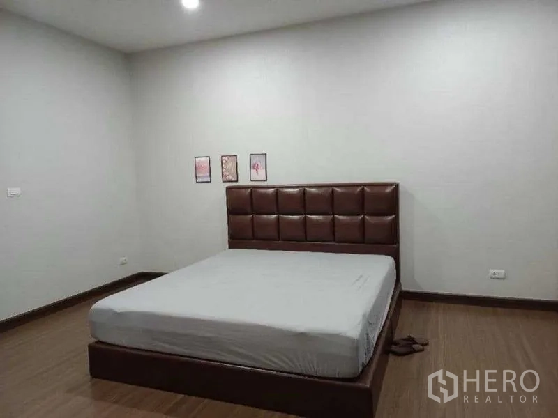 独立式住宅 出租在Mueang Nonthaburi, Nonthaburi - 极简卧室，棕色软包床头与木地板。