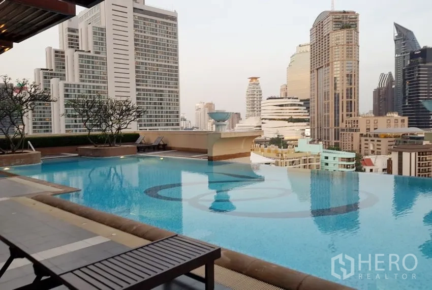 Condominium for rent or sale in Khlong Toei, Bangkok - Rooftop swimming pool with Bangkok skyline views and surrounding high-rise buildings.