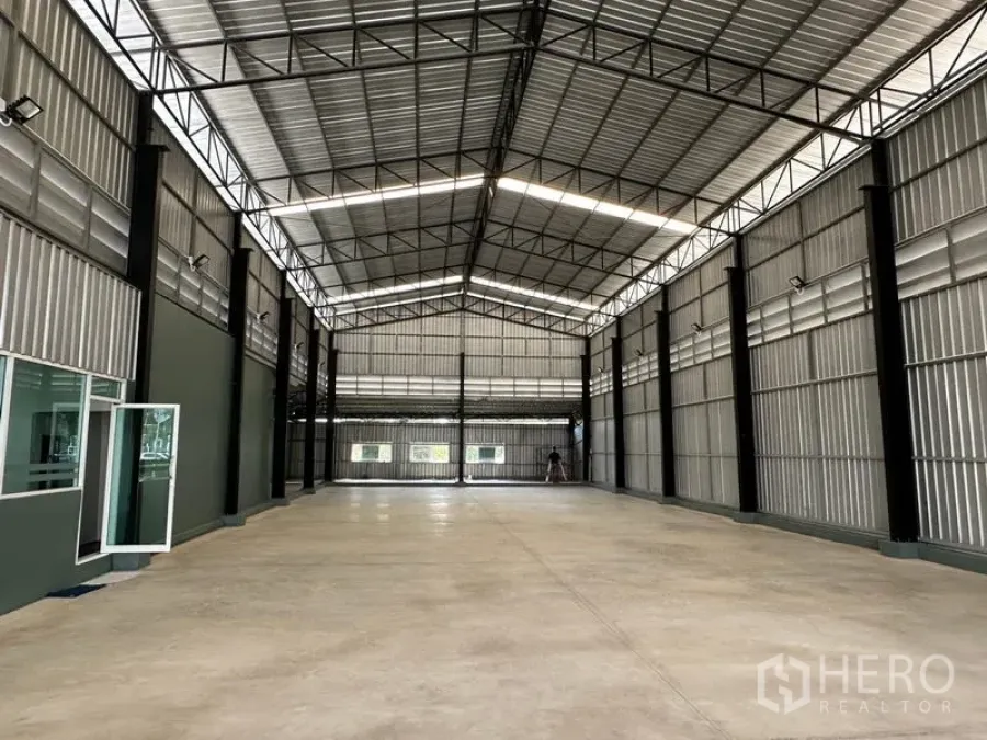 Warehouse for rent in Lat Krabang, Bangkok - Spacious warehouse interior with high gabled roof, steel beams, ample lighting, and polished concrete floor.
