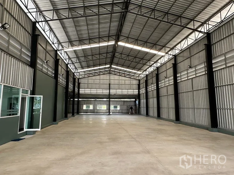 Warehouse for rent in Lat Krabang, Bangkok - Spacious warehouse interior with high gabled roof, steel beams, ample lighting, and polished concrete floor.