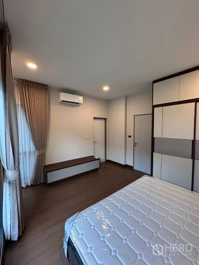 独立式住宅 出租在Bang Phli, Samut Prakan - 次卧，配床、空调与落地窗帘。