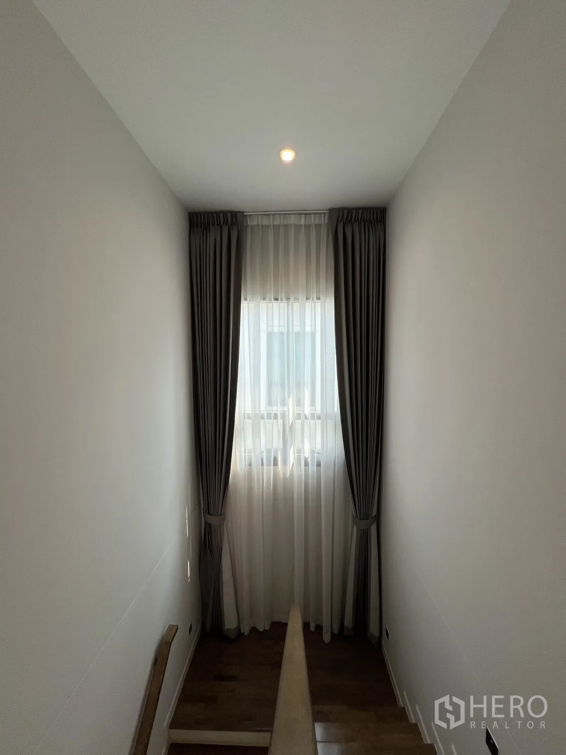 Detached House for rent in Bang Phli, Samut Prakan - Stairwell landing with a tall window and double curtains.