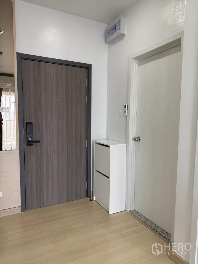 公寓 出租在Khlong Toei, Bangkok - 入户区，木纹门、白色鞋柜与浅色木地板。