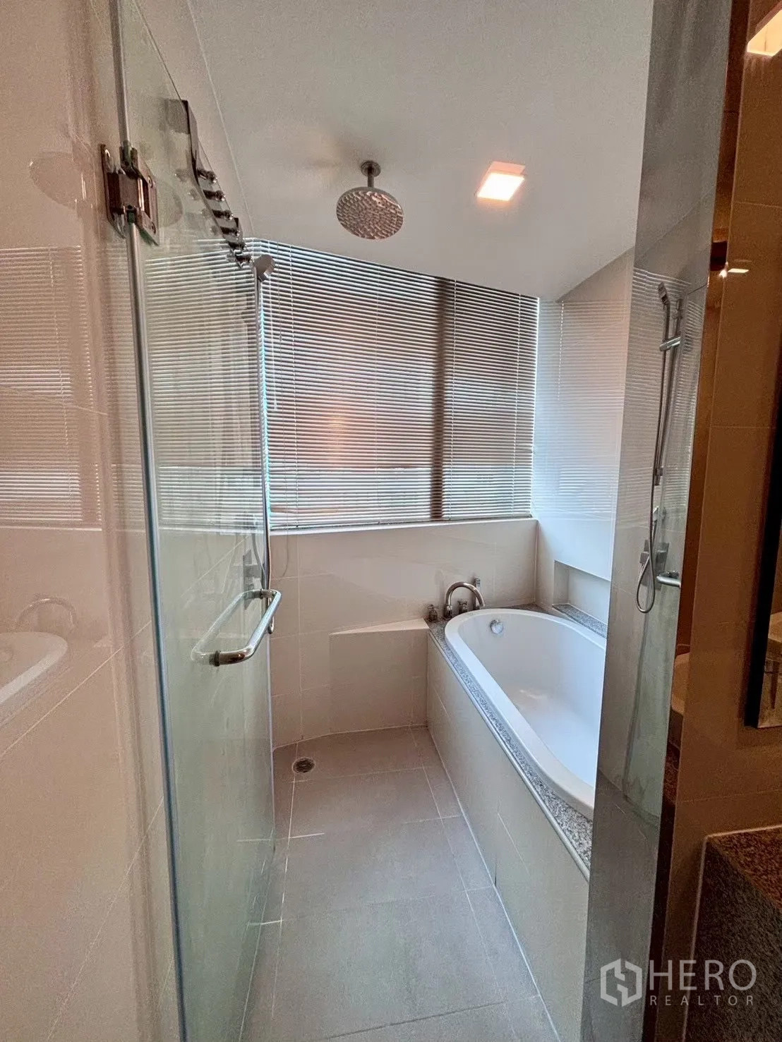 Condominium for rent in Khlong Toei, Bangkok - Bathroom with bathtub by the window and separate shower enclosure