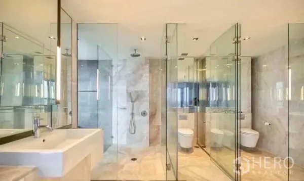 Condominium for rent in Sathon, Bangkok - Luxurious marble bathroom with glass shower enclosures and premium fixtures