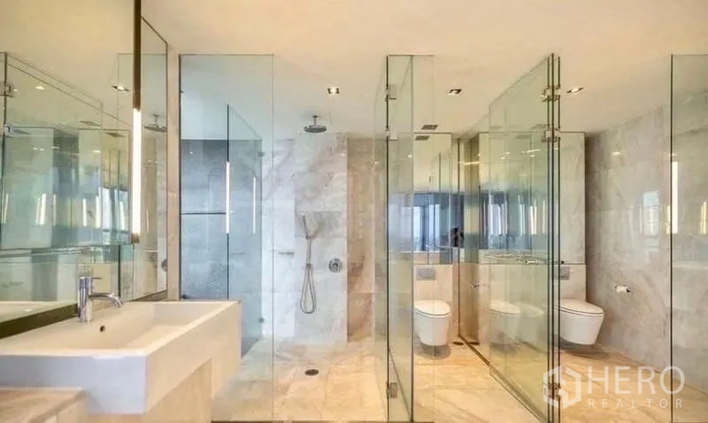 Condominium for rent in Sathon, Bangkok - Luxurious marble bathroom with glass shower enclosures and premium fixtures