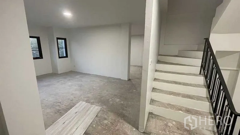 Townhouse for sale in Prawet, Bangkok - Gated multi-storey townhouse facade with balconies and parking area.