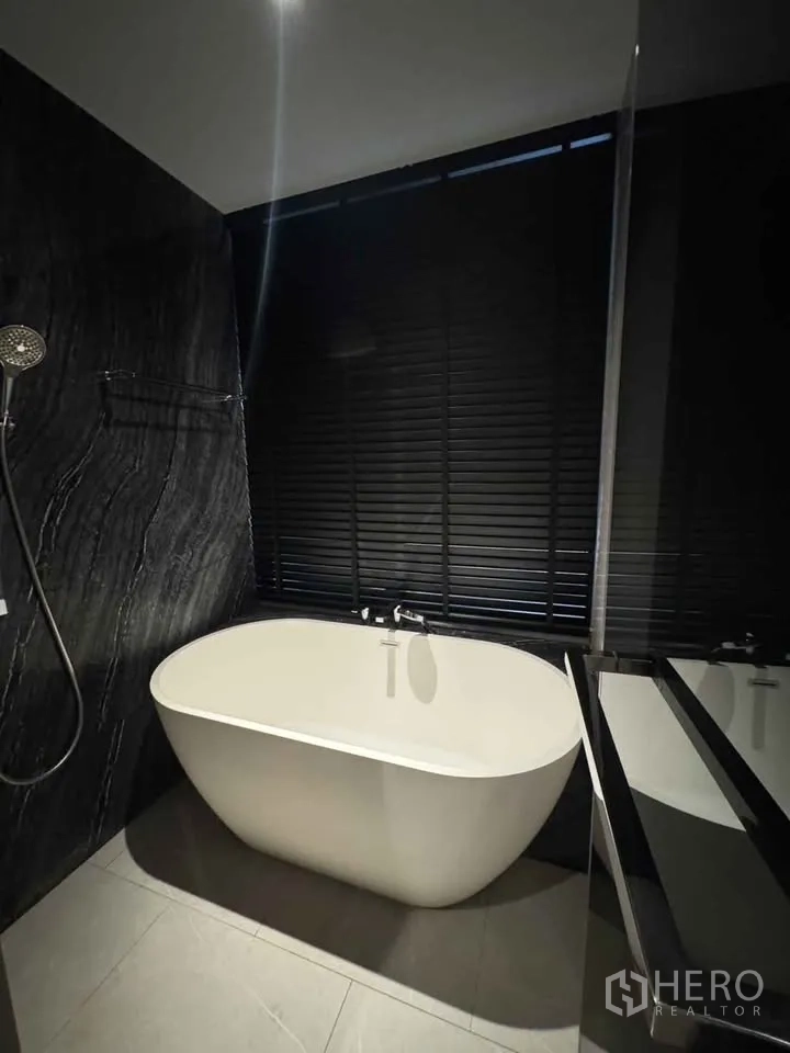 公寓 for rent in Watthana, Bangkok - 现代卫浴内设独立式浴缸与深色石材墙面。