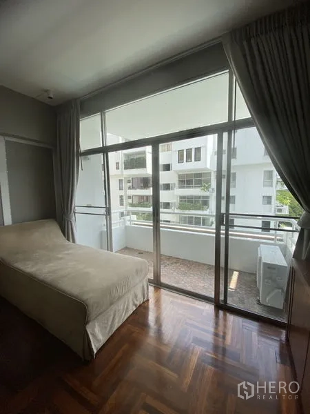 公寓 出租在Sathon, Bangkok - 卧室推拉门通往带顶阳台，可眺望周边住宅楼。
