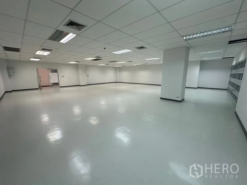 Office Space for rent in Bang Rak, Bangkok - Open workspace with ceiling lighting, air-conditioning and double doors leading to an adjacent service area.