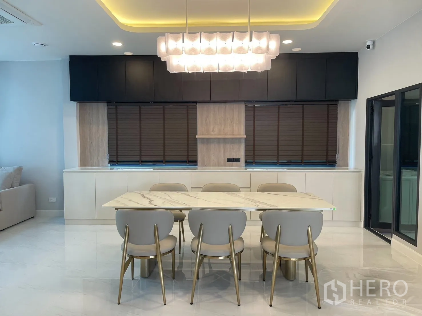 Detached House for rent in Bang Phli, Samut Prakan - Dining room with statement chandelier and six chairs by large windows.