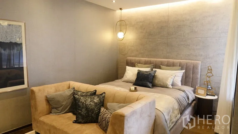 บ้าน ขายในPrawet, Bangkok - ห้องนอนมาสเตอร์อบอุ่น เตียงบุผ้า โคมแขวน และโซฟาปลายเตียง