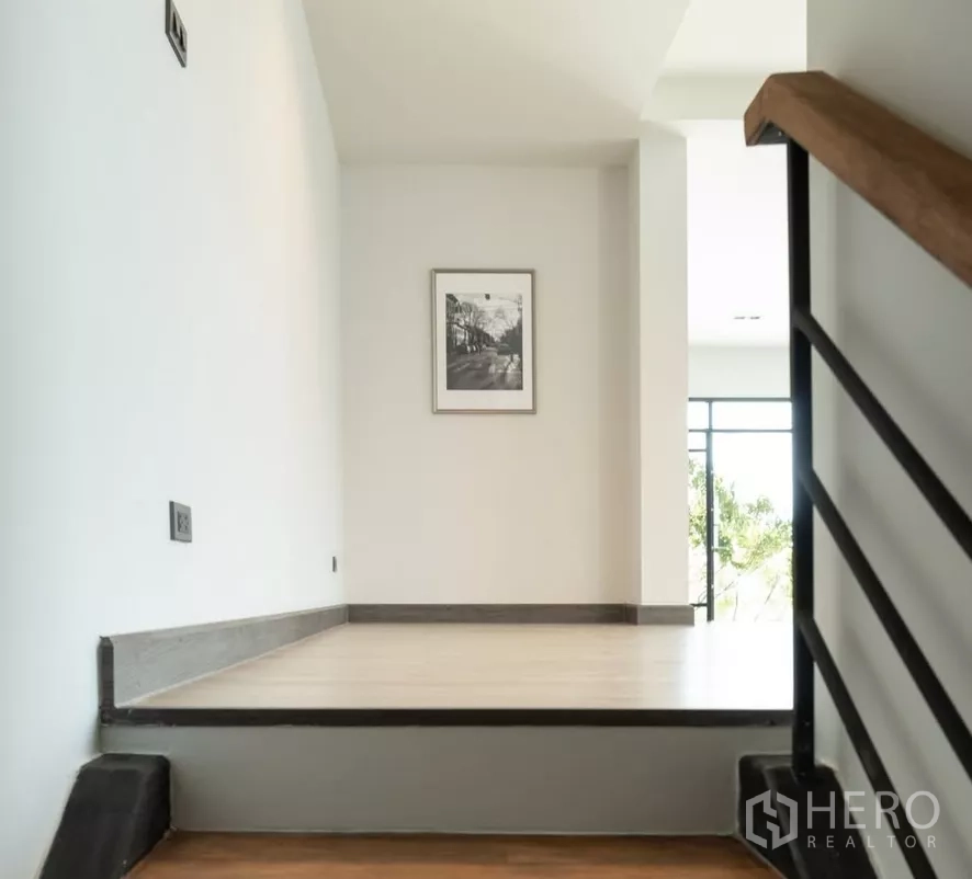 Home Office for sale in Bang Kapi, Bangkok - Minimal hallway landing with railing and framed artwork.
