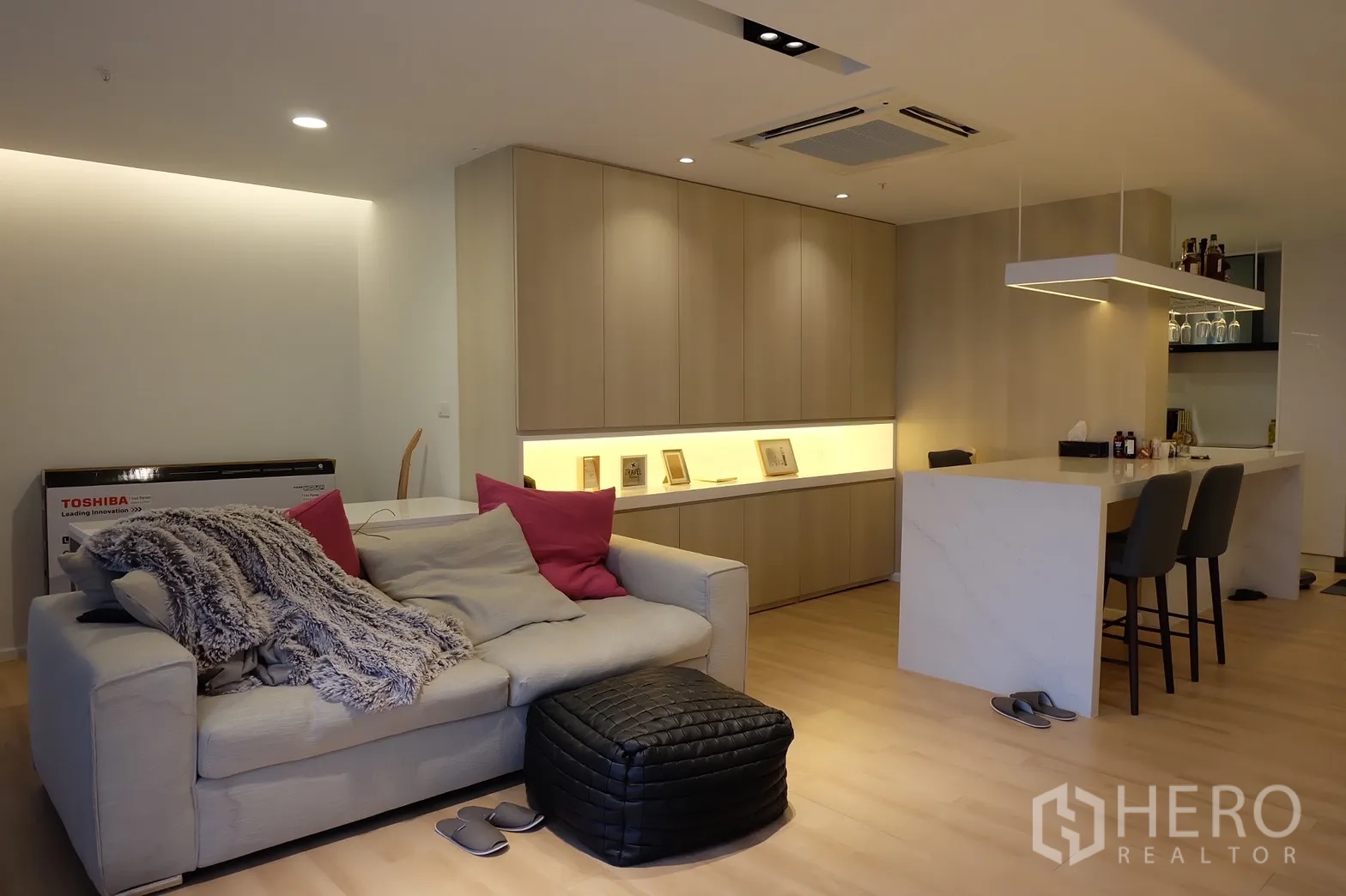 Condominium for rent in Bang Rak, Bangkok - Cozy lounge area with sofa, built-in cabinets and warm accent lighting.