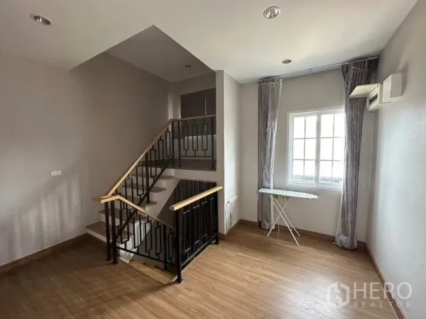 Detached House for sale in Bang Khen, Bangkok - Staircase with black metal railing and a landing area lit by a window.