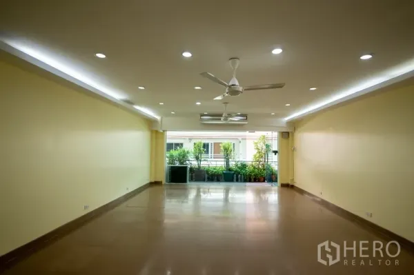 Home Office for rent - Spacious open-plan room with recessed lights, ceiling fans and glass doors to a balcony with potted plants.