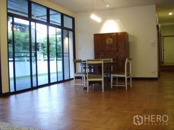 บ้าน ให้เช่าในHuai Khwang, Bangkok - ส่วนรับประทานอาหาร พื้นปาร์เกต์ โคมไฟห้อย และประตูกระจกบานเลื่อนออกสวน