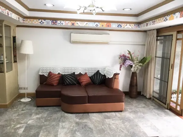 联排别墅 出租在Khlong Toei, Bangkok - 第二起居室，转角沙发、空调、落地灯与推拉玻璃门。