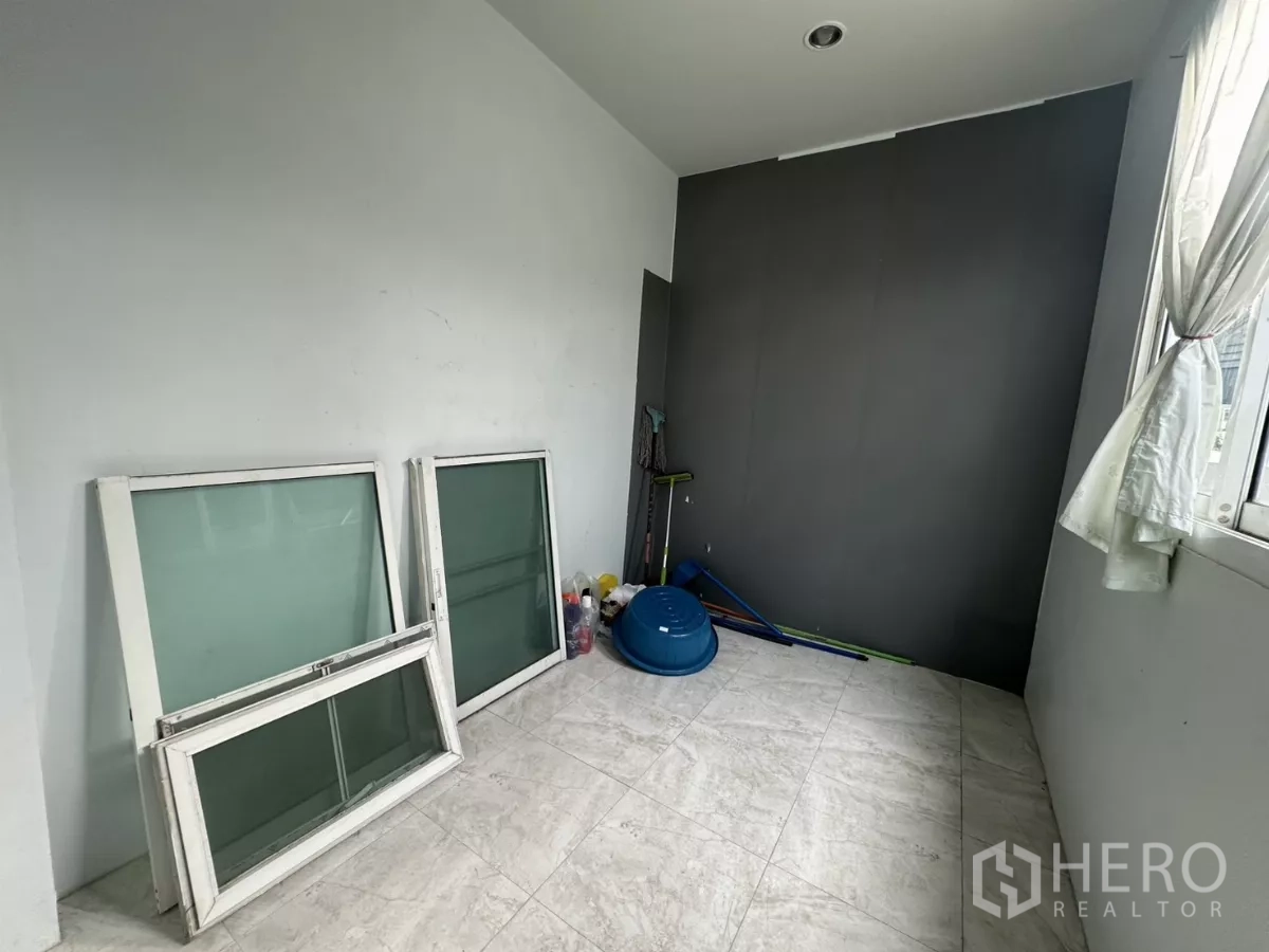 Home Office for rent - Compact storage room containing spare window frames and cleaning tools.