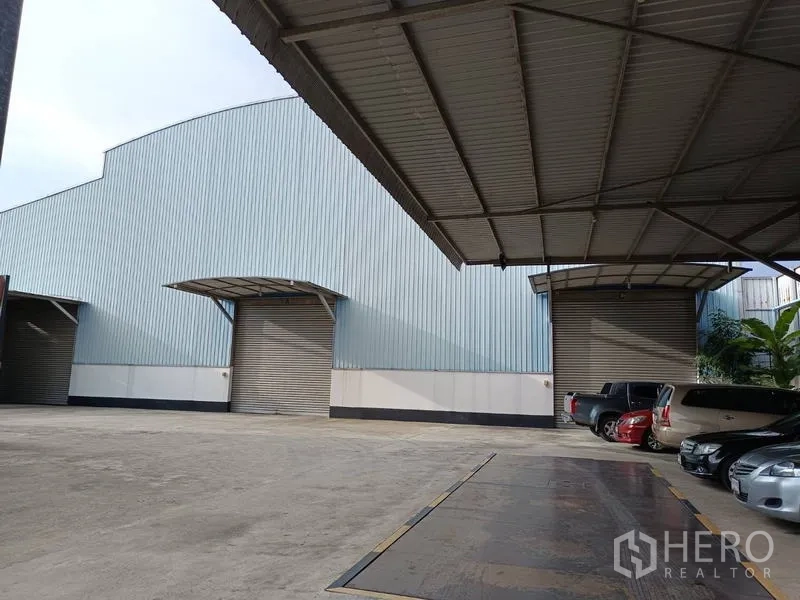 โรงงาน ขายในBan Phaeo, Samut Sakhon - ด้านหน้าโรงงานโลหะกว้าง ประตูม้วนใต้กันสาด พร้อมพื้นที่จอดรถ