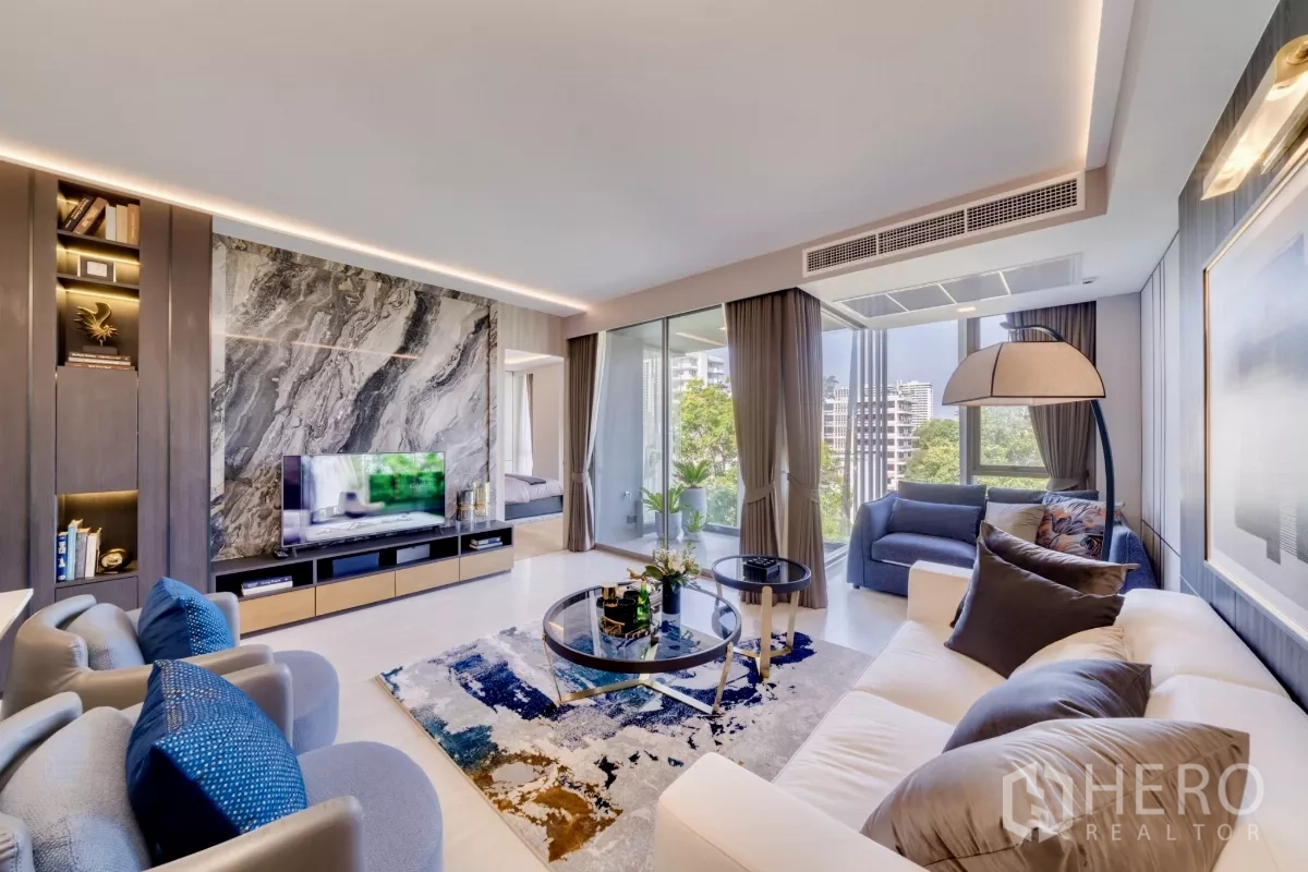 公寓 出租在Watthana, Bangkok - 客厅设大理石电视墙、阳台角落与绿树景观。