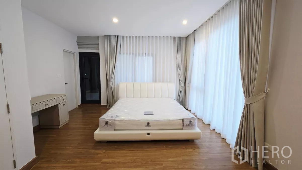 独立式住宅 出租在Prawet, Bangkok - 明亮套房卧室，带书桌与环窗窗帘。