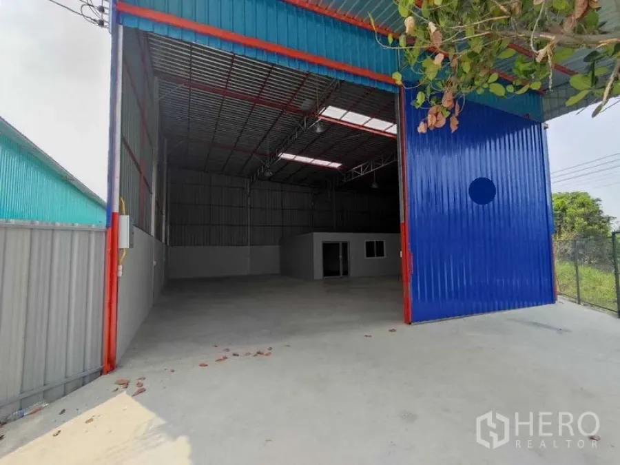 货栈 出租在Pak Kret, Nonthaburi - 高挑仓库，蓝色大型推拉门，混凝土前场，内设办公室。