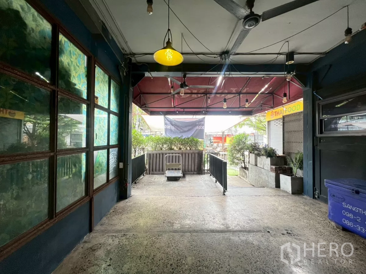 พื้นที่ขายปลีก ให้เช่า - ชานหน้าร้านแบบมีหลังคา ตกแต่งไฟ แขวน พร้อมราวกั้นและกระบะต้นไม้