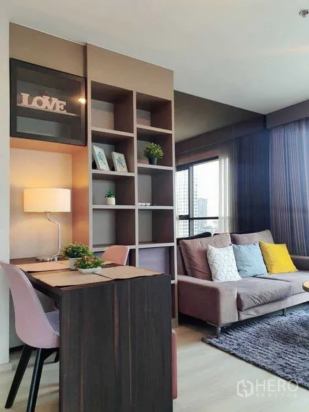 Condominium for sale in Khlong Toei, Bangkok - Bright living area with built‑in shelves, work desk, and sofa beside floor‑to‑ceiling windows at Life Sukhumvit 48.