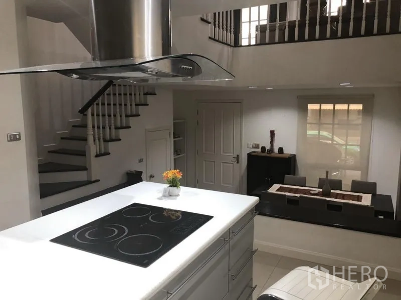 Townhouse for rent in Bang Kapi, Bangkok - View from the kitchen toward the staircase and dining area in a split-level layout.