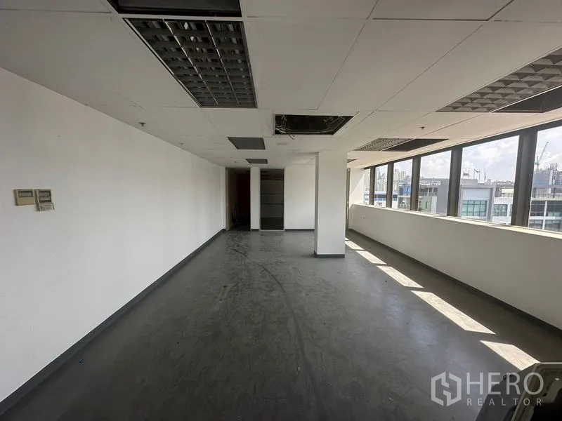 办公空间 出租在Khlong Toei, Bangkok - 长条形开放式办公区，整排窗户与城市景观。