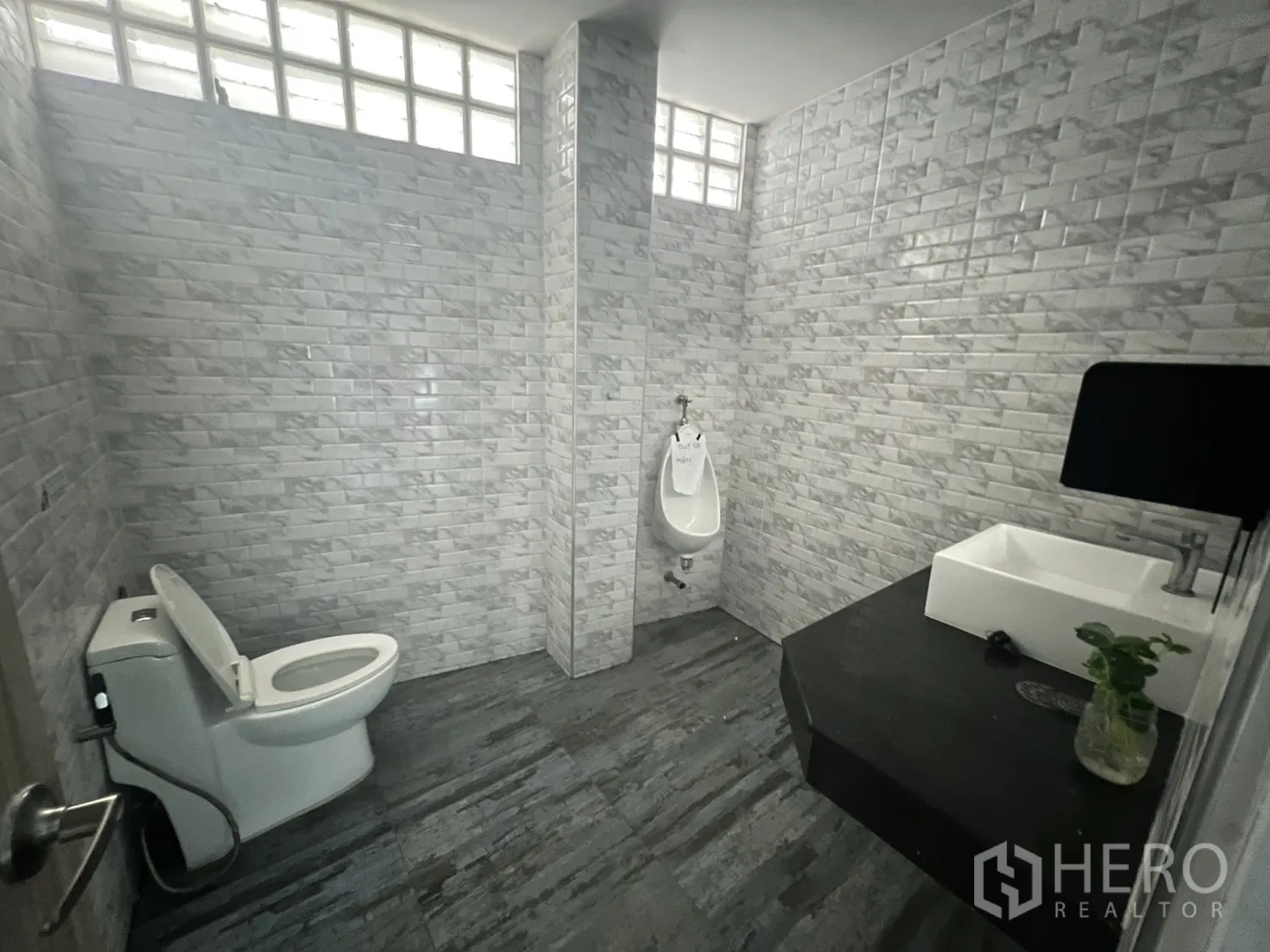 Retail Space for rent in Khlong Toei, Bangkok - Renovated restroom with grey wall tiles, toilet, urinal and basin.