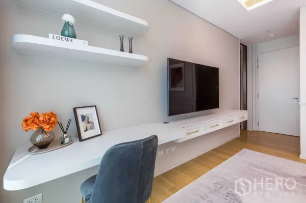 Condominium for sale in Pathum Wan, Bangkok - Workstation with floating desk, shelves and wall-mounted TV in a minimalist room