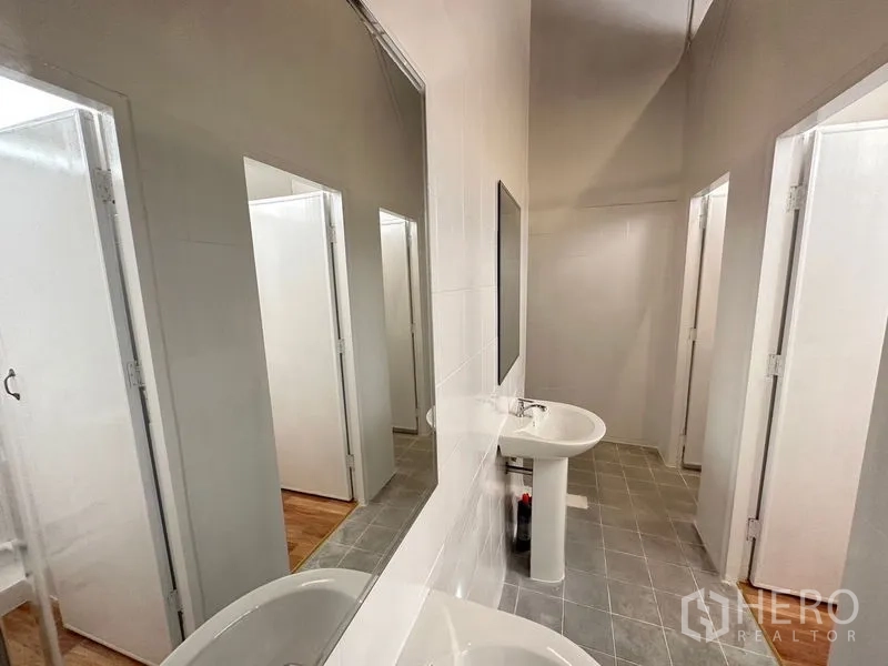 Office Space for rent in Bang Sao Thong, Samut Prakan - Clean restroom corridor with pedestal sinks and multiple private stalls.