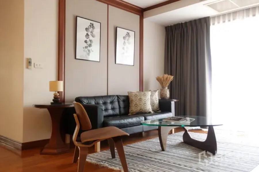 公寓 出租在Khlong Toei, Bangkok - 起居区，黑色皮沙发、设计师椅与玻璃茶几。