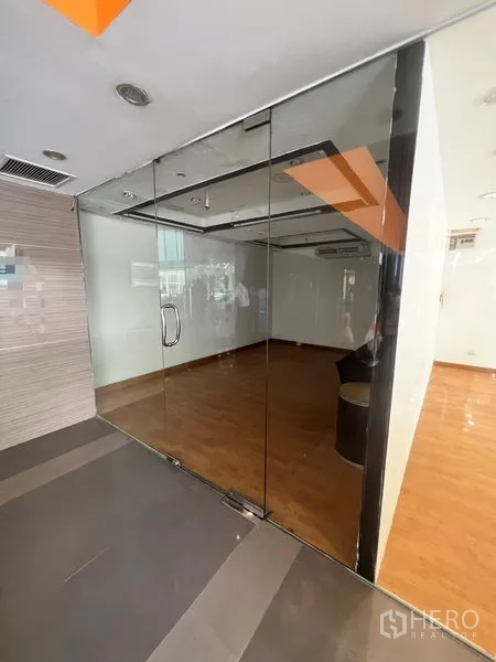 Retail Space for rent - Glass-fronted retail unit with wood flooring and recessed lighting inside a mall corridor.
