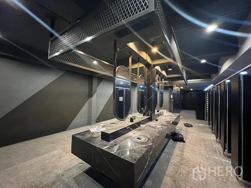 Showroom for rent in Mueang Samut Prakan, Samut Prakan - Industrial-style washroom with long black marble vanity, mirrors and lighting
