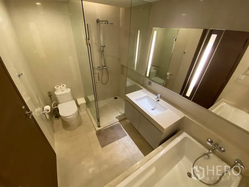 คอนโด ให้เช่าหรือขายในWatthana, Bangkok - ห้องน้ำสมัยใหม่พร้อมตู้กระจก อ่างอาบน้ำ อ่างล้างหน้า และฉากกั้นอาบน้ำแบบกระจก